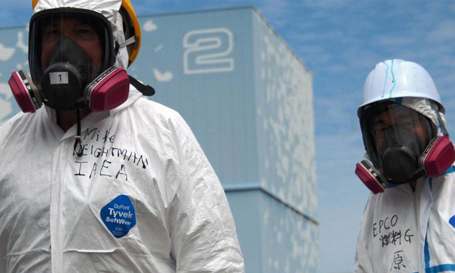 Two men in white tyvek suits and masks