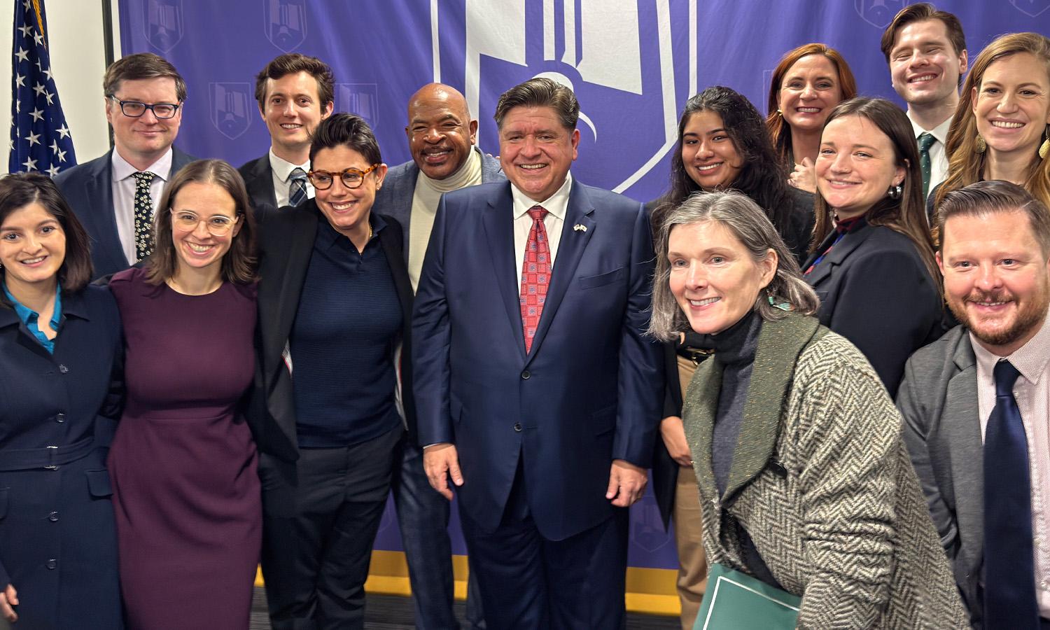 A group of people smiling at the Clean and Reliable Grid Affordability Act signing.