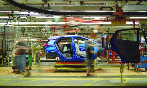 Auto workers construct a car