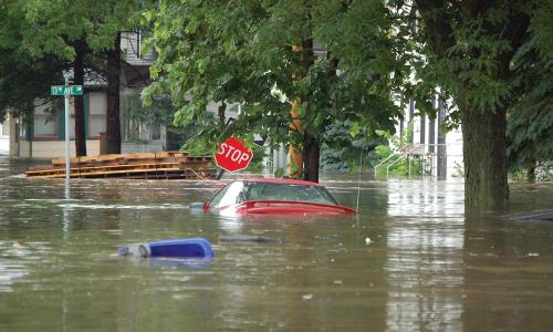 A red sedan is mostly submerged in flood waters in Cedar Rapids, IA. 