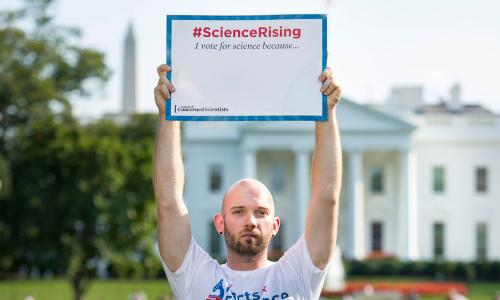 UCS scientist Jacob Carter holding up a Science Rising sign