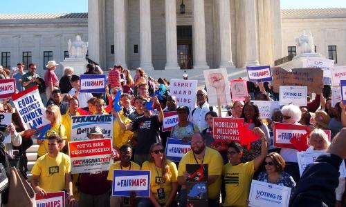 Crowd carrying signs at voting rights rally