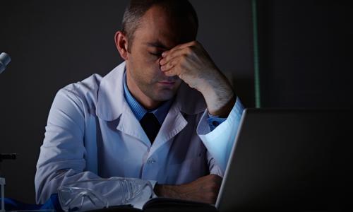 Scientist looking down in a dark lab