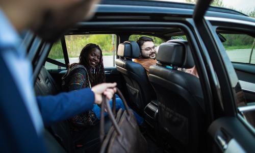 Man and woman getting into ride-hailing car