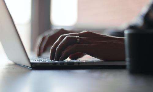 Person typing on laptop.