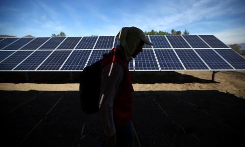 A person walking past solar panels