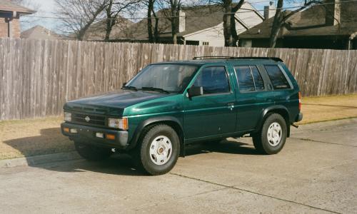 Older Nissan SUV parked in residential neighborhood