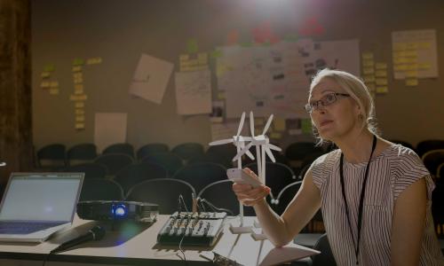 A person controlling a presentation with clean energy models on their desk