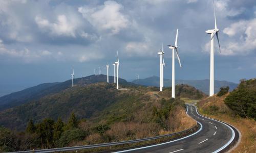 A road winding through wind turbines