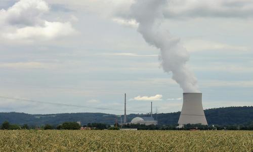 A wide shot of a field and nuclear reactor.