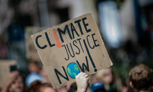 A protester's sign reading Climate Justice Now