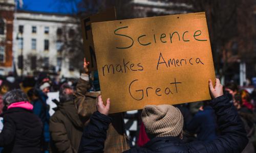 A protester with a sign that reads Science makes America Great