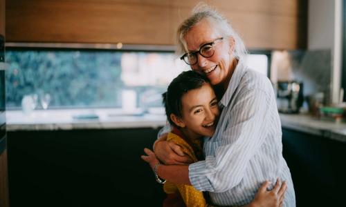 A grandparent hugging her grandchild