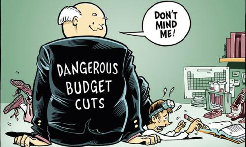 A comic depicting a man in a suit labeled "dangerous budget cuts" sits on top of a scientist, preventing him from doing work.
