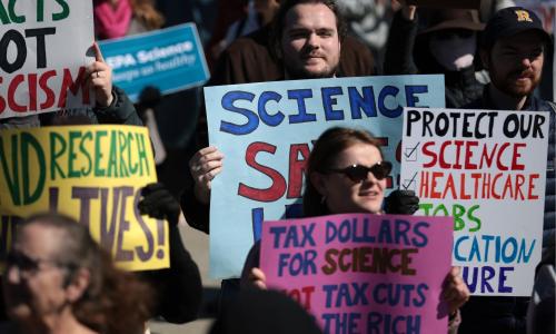 Protestors at a rally for science holding up signs. 