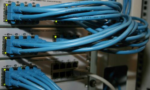 A server rack with blue cables coming out of it.