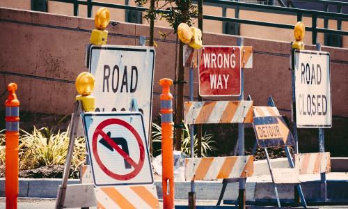 several road signs signaling a detour or construction