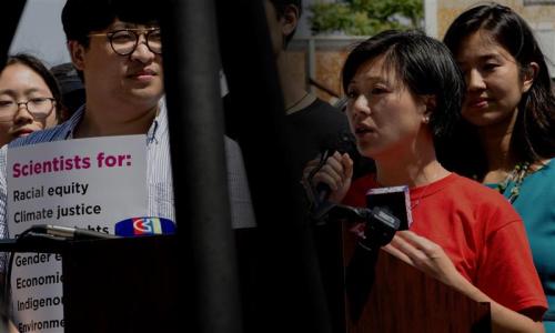 someone speaking alongside someone holding a pro science sign