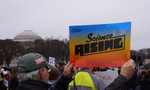 A person holds a sign reading Science Rising. Photo credit: Eric Schulz