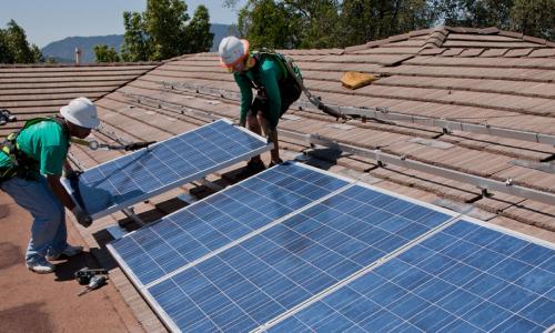 Workers installing rooftop solar panels