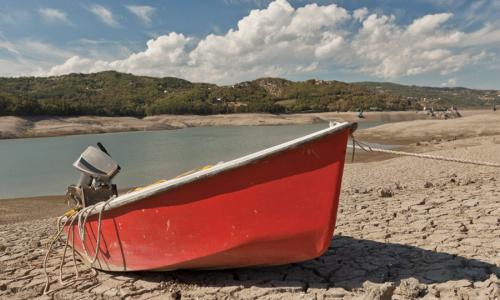 A boat on a dry lakeshore.